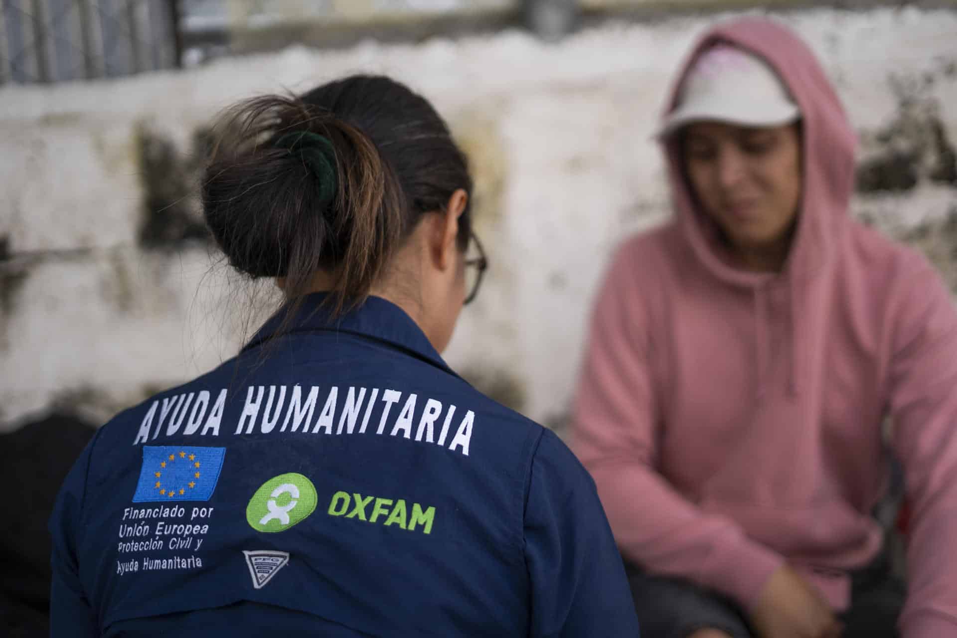 Fotografía cedida por Oxfam que muestra una funcionaria de esta organización mientras hablan con migrantes centroamericanos en Costa Rica. EFE/Oxfam