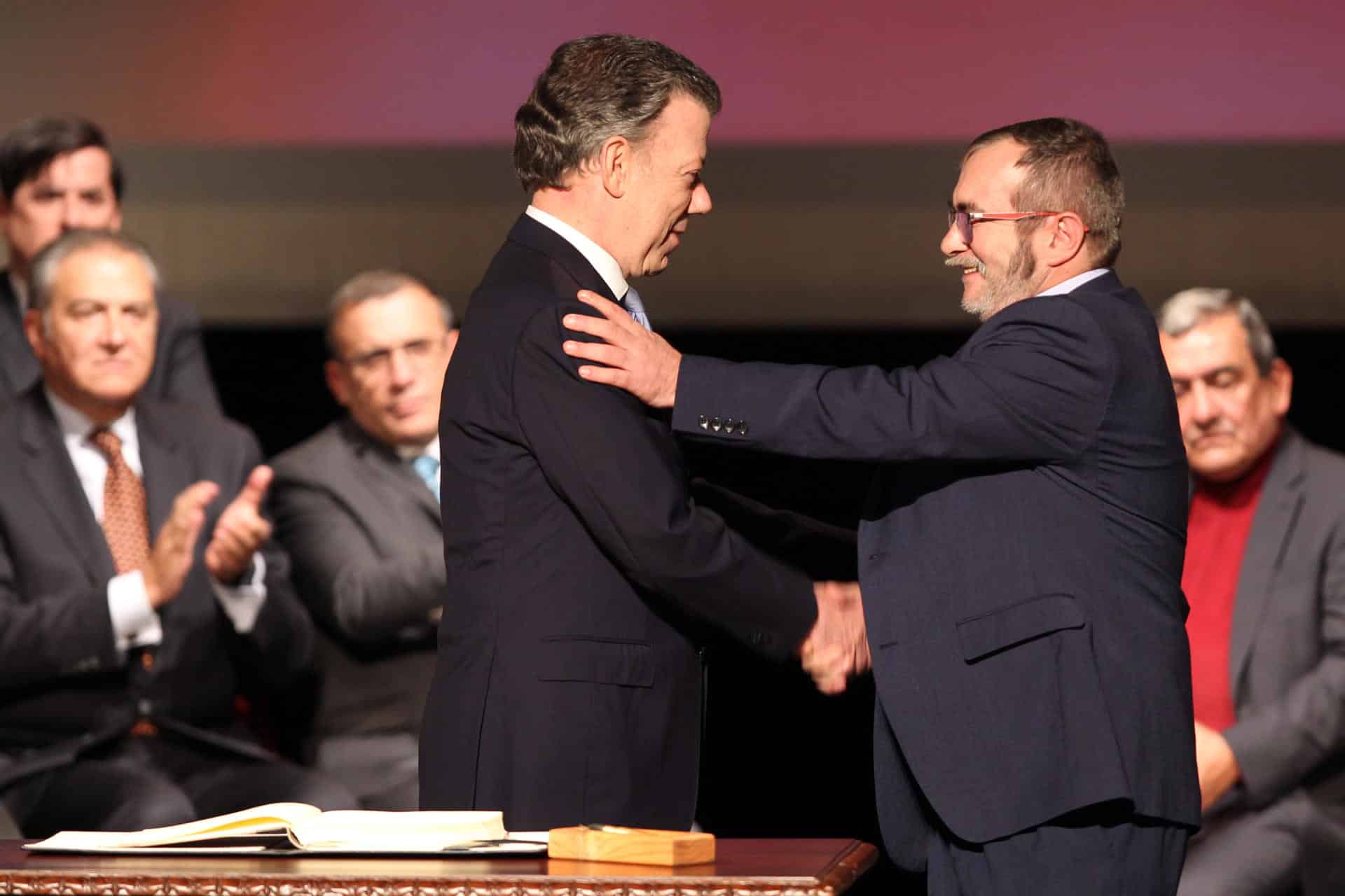 Fotografía del 24 de noviembre de 2016 en donde el entonces presidente de Colombia, Juan Manuel Santos (i), y el jefe máximo de las FARC, Rodrigo Londoño Echeverry (d), se felicitan luego de firmar el acuerdo de paz para terminar 52 años de conflicto armado interno. EFE/MAURICIO DUENAS CASTAÑEDA