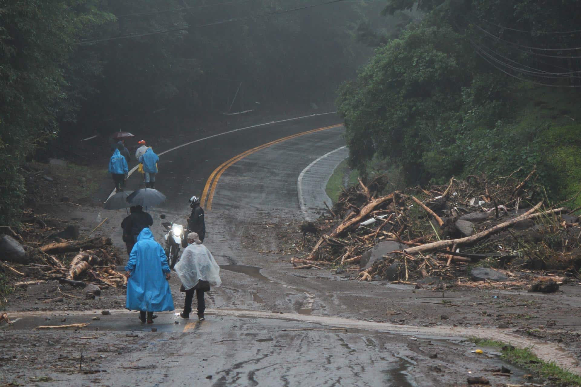 Fotografía de archivo en donde se ven habitantes que caminan por una zona afectada tras las fuertes lluvias. EFE/ Marcelino Rosario