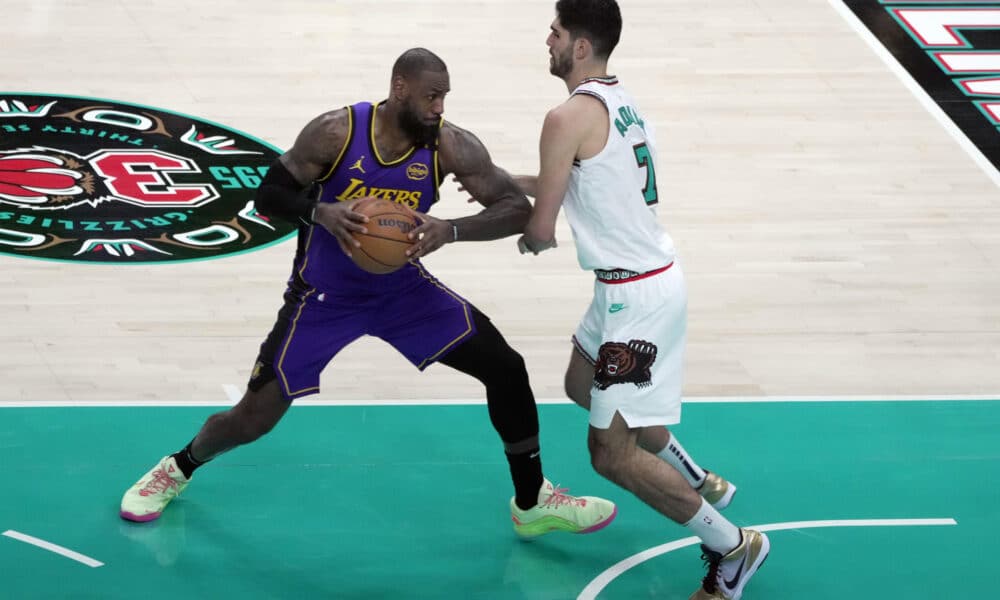 El alero Santi Aldama (d) de Grizzlies defiende la entrada a canasta del alero LeBron James, de Los Lakers, durante el partido entre Memphis Grizzlies y Los Angeles Lakers, en el FedEx Forum en Memphis, Tennesse (Estados Unidos).EFE/ Karen Pulfer Focht