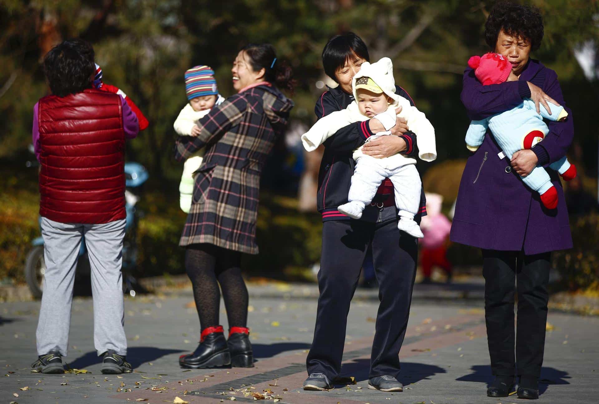 Fotografía de archivo que muestra a varias mujeres sujetando en brazos a bebés en un parque de Pekín, China. EFE/Diego Azubel