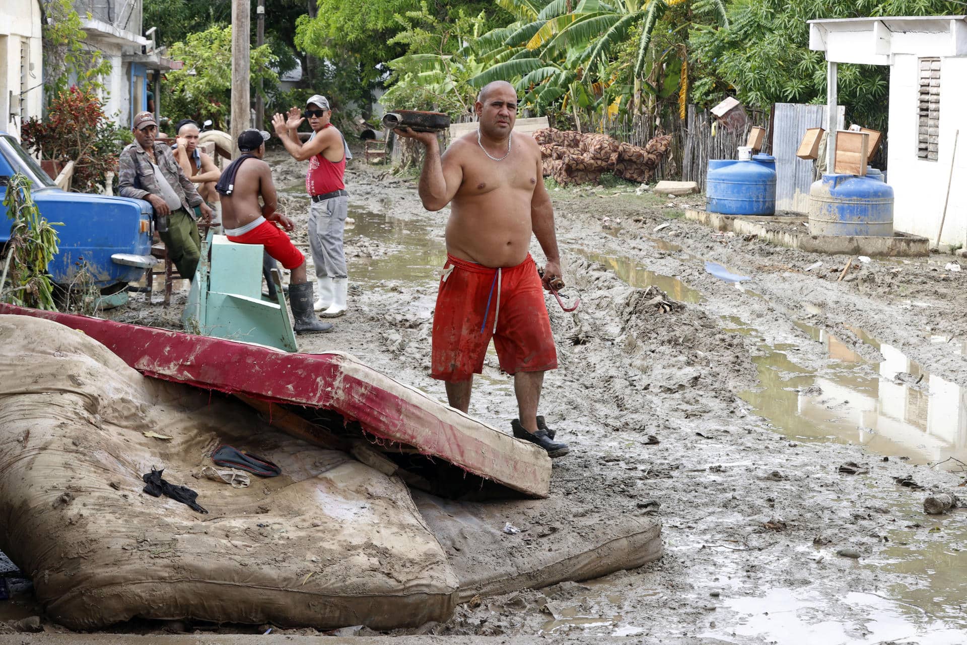 Foto de archivo de un hombre caminando junto a colchones destruidos en el exterior de una vivienda en la región de San Antonio del Sur tras el paso de la tormenta tropical Óscar, en la provincia de Guantánamo, a más de 900 km de La Habana (Cuba). EFE/ Ernesto Mastrascusa POOL