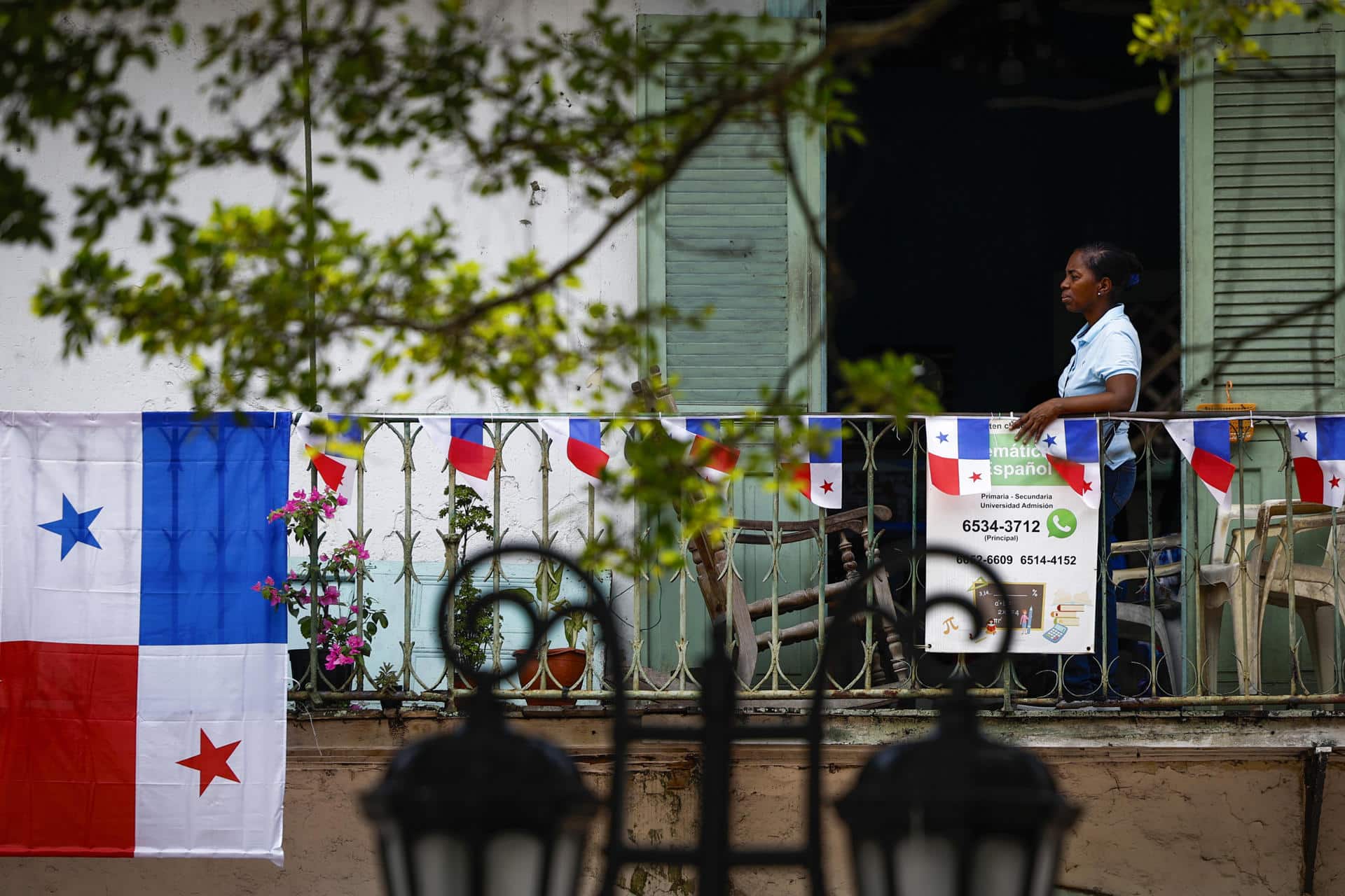 Una persona observa desde un balcón la conmemoración del día de los Símbolos Patrios en el Casco Viejo en ciudad de Panamá (Panamá). EFE/ Bienvenido Velasco