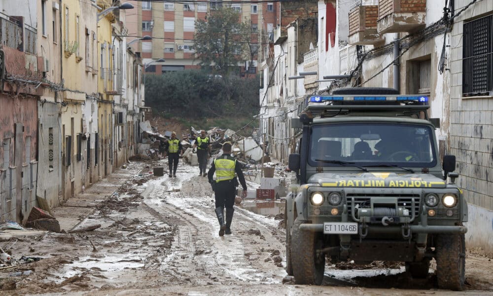 Policía militar y Guardia Civil en una calle aledaña al Barranco de Torrente, este lunes. La provincia de Valencia intenta retomar la actividad laboral y las clases en los colegios mientras continúan de forma intensa las labores de búsqueda de desaparecidos, de abastecimiento y atención a los damnificados, y de la limpieza de las calles y bajos de numerosos municipios, sobre los que ha vuelto a llover este domingo. EFE/Miguel Ángel Polo