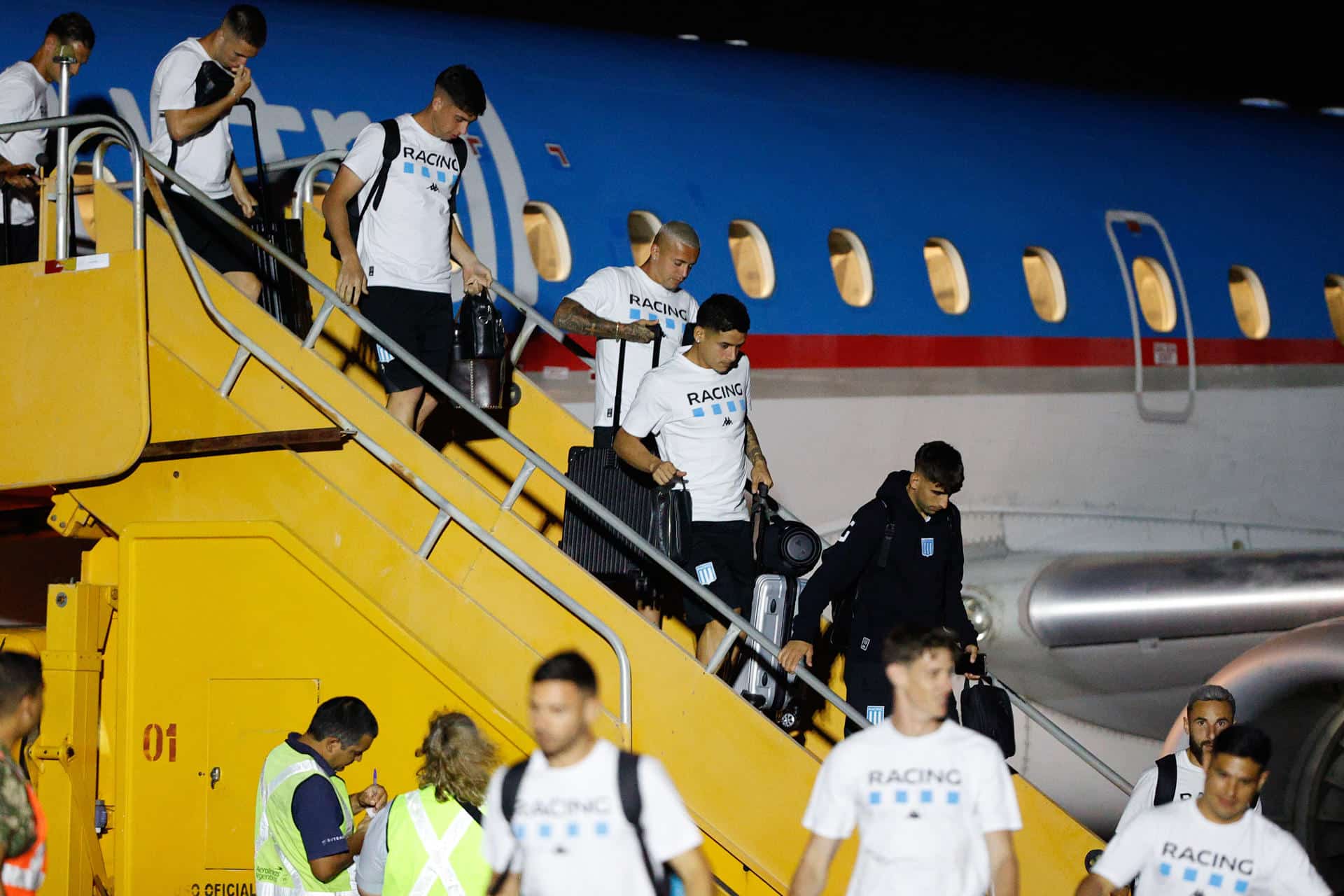 Jugadores de Racing Club descienden este miércoles del avión que los trajo desde Argentina a Paraguay en cuya capital, Asunción, disputarán este sábado contra Cruzeiro, la final de la vigésima tercera edición de la Copa Sudamericana. EFE/ Juan Pablo Pino