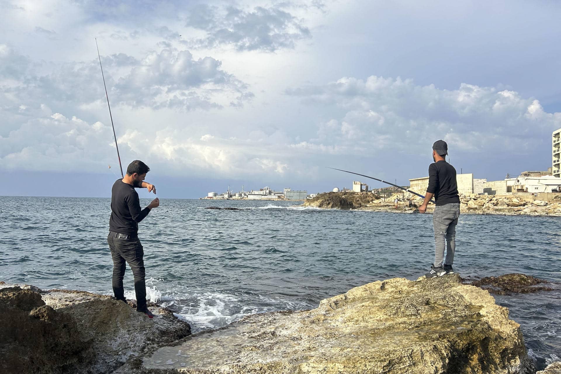 Pescadores tratan de pescar con caña en una cala de la localidad de Batrún, a unos 54 kilómetros al norte de Beirut. EFE/ Rosa Soto