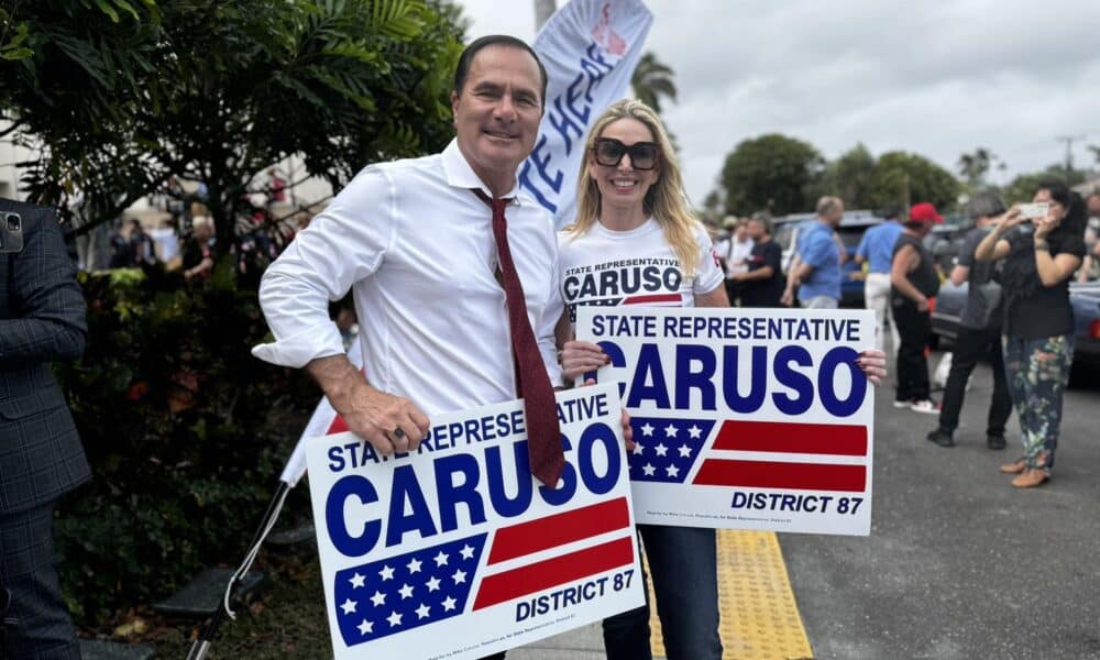 El representante estatal Mike Caruso sostiene unas pancartas de su campaña este martes en Palm Beach, Florida (Estados Unidos). EFE/ Alicia Civita