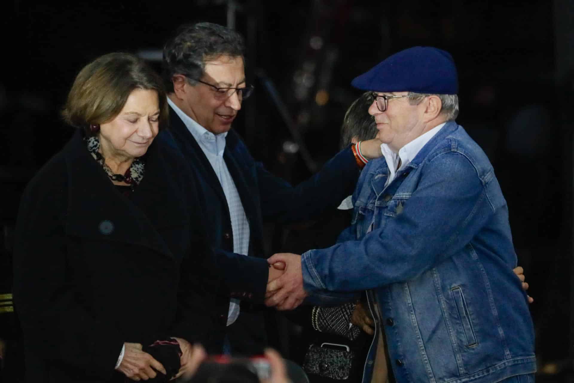 El excomandante de las de las Fuerzas Armadas Revolucionarias de Colombia (FARC), Rodrigo Londoño (d), saluda al presidente de Colombia, Gustavo Petro (c), durante la ceremonia de conmemoración del octavo aniversario de la firma de acuerdo de paz este jueves, en la plaza de Bolívar en Bogotá (Colombia). EFE/ Carlos Ortega