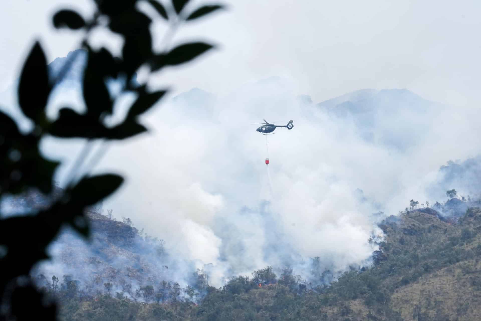 Fotografía cedida por el Cuerpo de Bomberos de Cuenca de un helicóptero combatiendo un incendio forestal en el Parque Nacional Cajas, en Cuenca (Ecuador). EFE/ Cuerpo de Bomberos de Cuenca