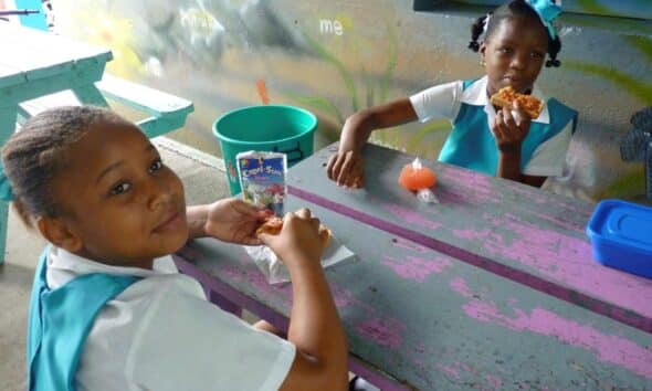 Fotografía de archivo en donde se ven dos niñas mientras toman su refrigerio en una escuela a las afueras de Castries, capital de la isla caribeña de Santa Lucía. EFE/Belén Delgado