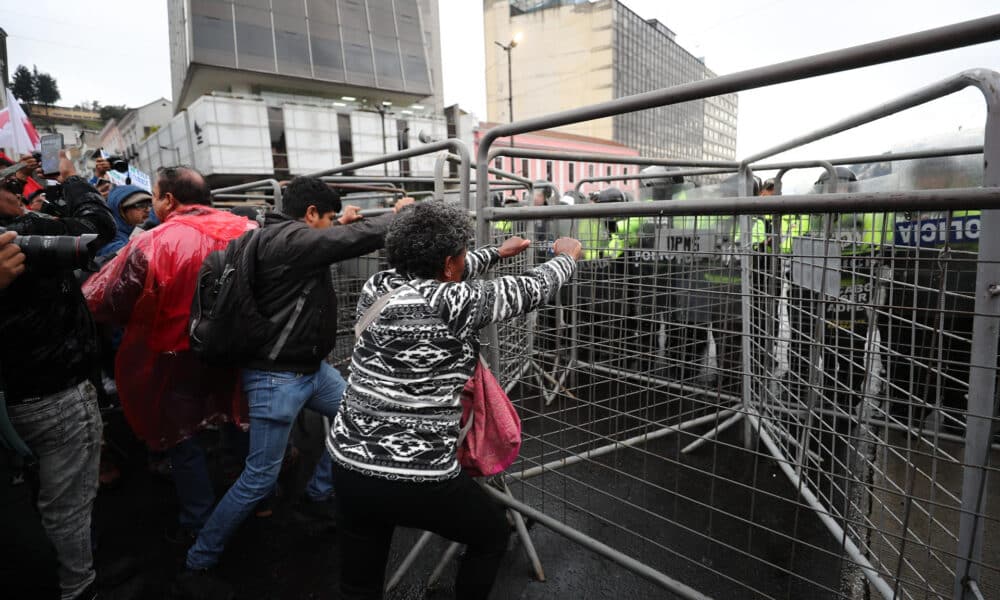 Manifestantes intentan mover rejas que impiden el paso al Centro Histórico este jueves, en Quito (Ecuador). EFE/ José Jácome