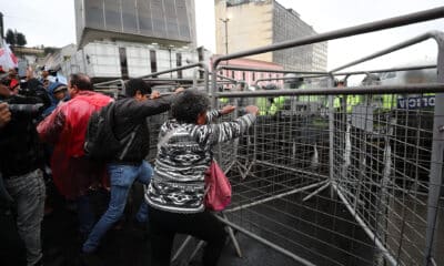 Manifestantes intentan mover rejas que impiden el paso al Centro Histórico este jueves, en Quito (Ecuador). EFE/ José Jácome