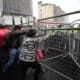 Manifestantes intentan mover rejas que impiden el paso al Centro Histórico este jueves, en Quito (Ecuador). EFE/ José Jácome