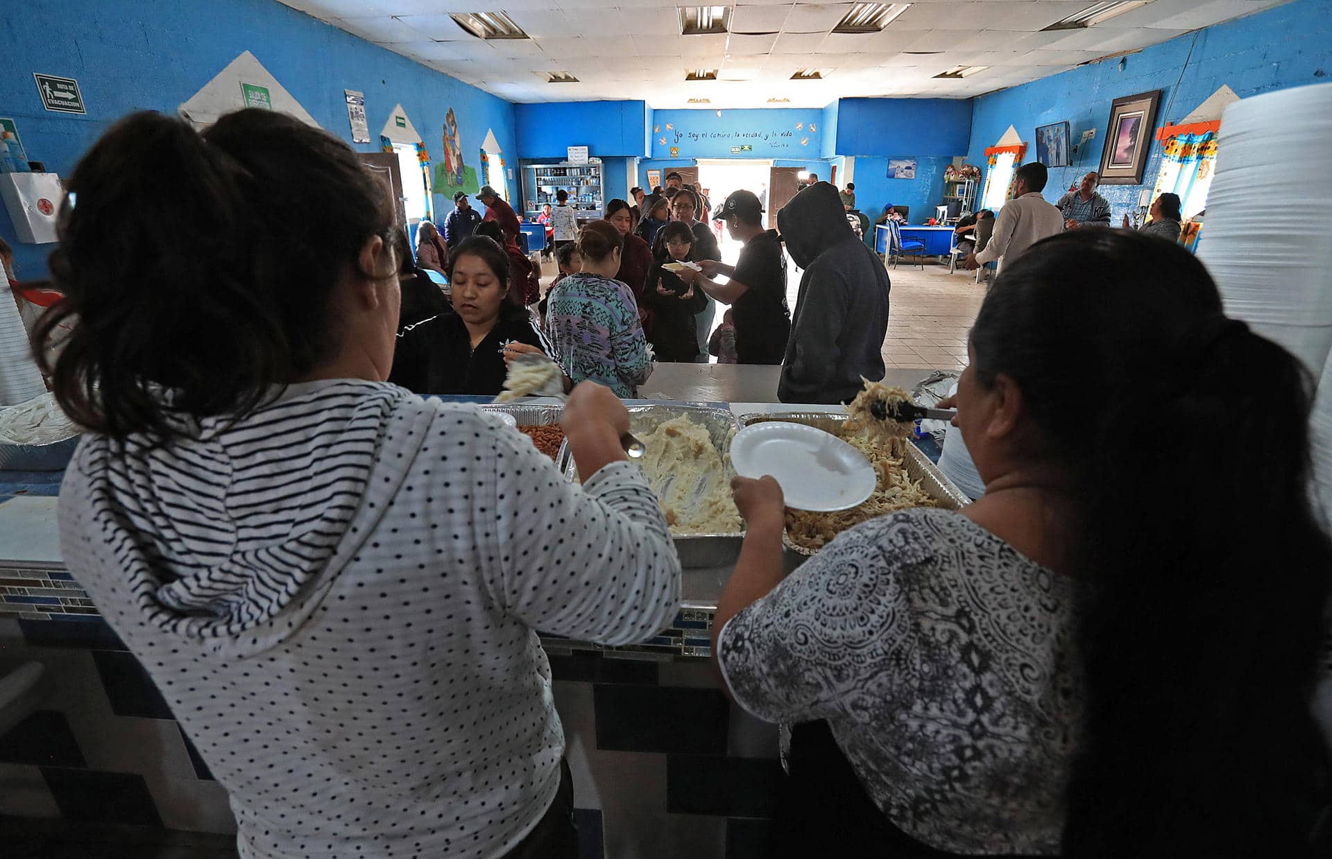 Migrantes reciben alimentos en el albergue 'Pan de Vida' con motivo del 'Día de Acción de Gracias', este jueves en Ciudad Juárez, estado de Chihuahua (México). EFE/ Luis Torres