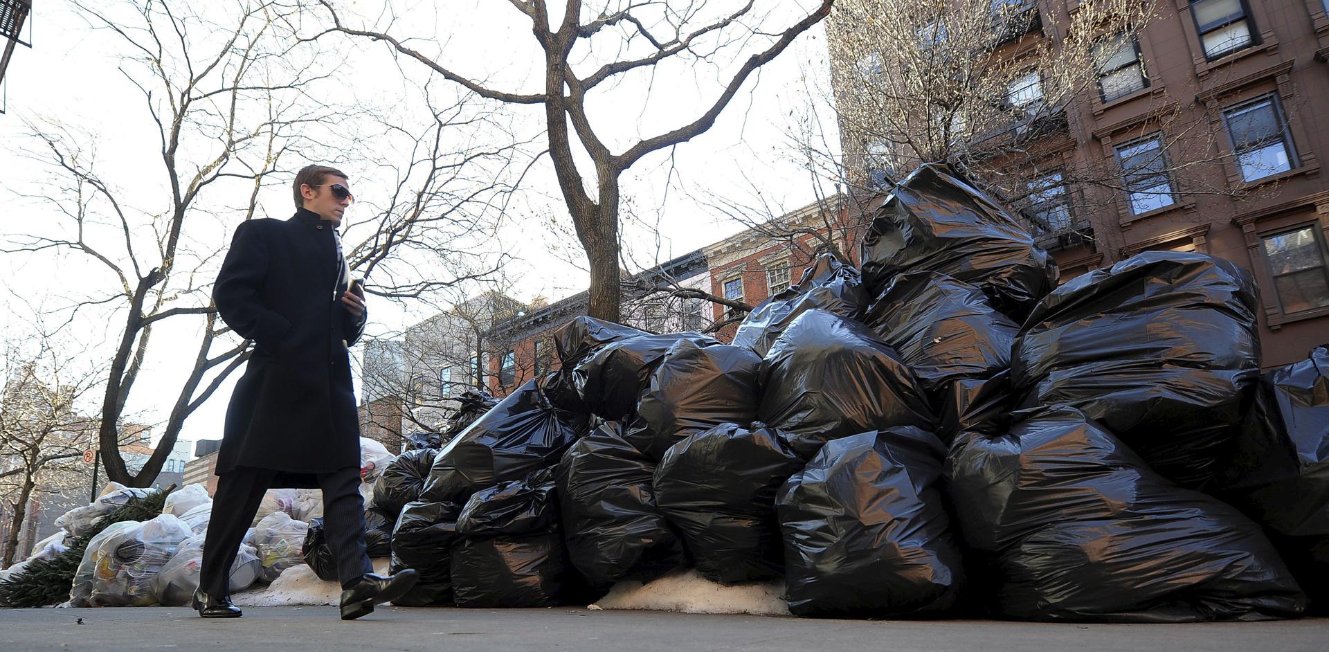 Un hombre pasa junto a una pila de bolsas de basura acumuladas en una calle de Nueva York. Foto de archivo. EFE/Justin Lane