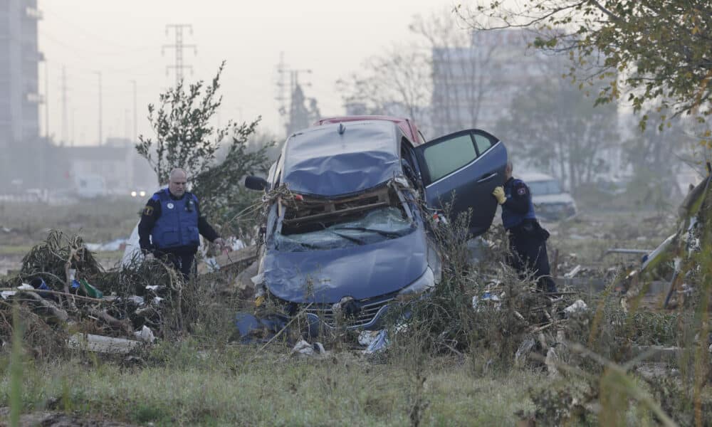 Dos policías locales inspeccionan un vehículo arrastrado por la riada en la pedanía de La Torre a las afueras de Valencia este miércoles. Voluntarios, fuerzas de seguridad, bomberos, militares y vecinos de las localidades más afectadas por la dana continúan con las tareas de limpieza mientras los equipos de rescate siguen rastreando la zona para intentar localizar a las personas que aún sigue desaparecidas. EFE/Ana Escobar