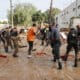 Voluntarios y fuerzas de seguridad trabajan para despejar una calle de Paiporta, este martes. EFE/ Manuel Bruque