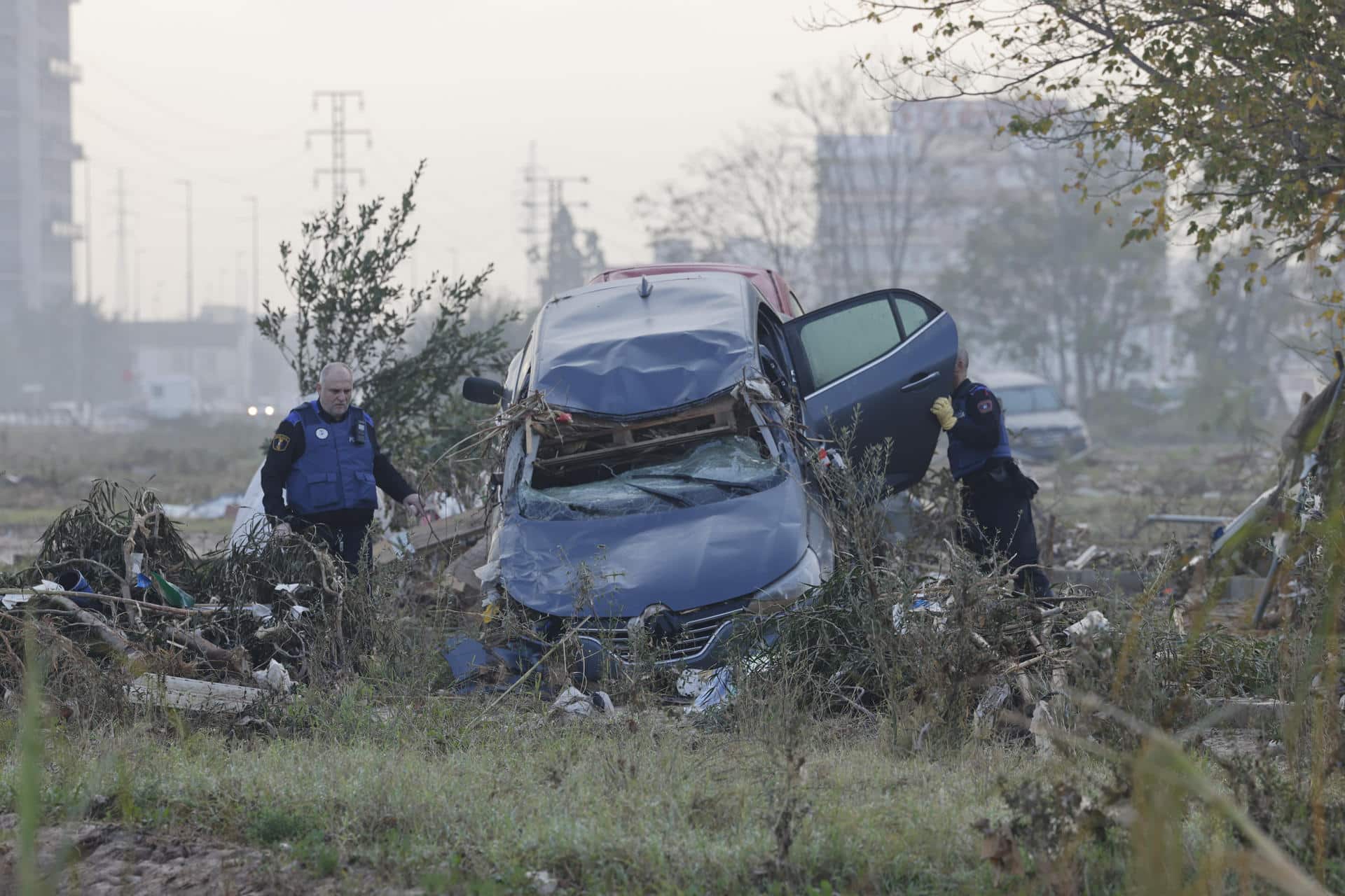 Voluntarios y fuerzas de seguridad trabajan para despejar una calle de Paiporta, este martes. EFE/ Manuel Bruque