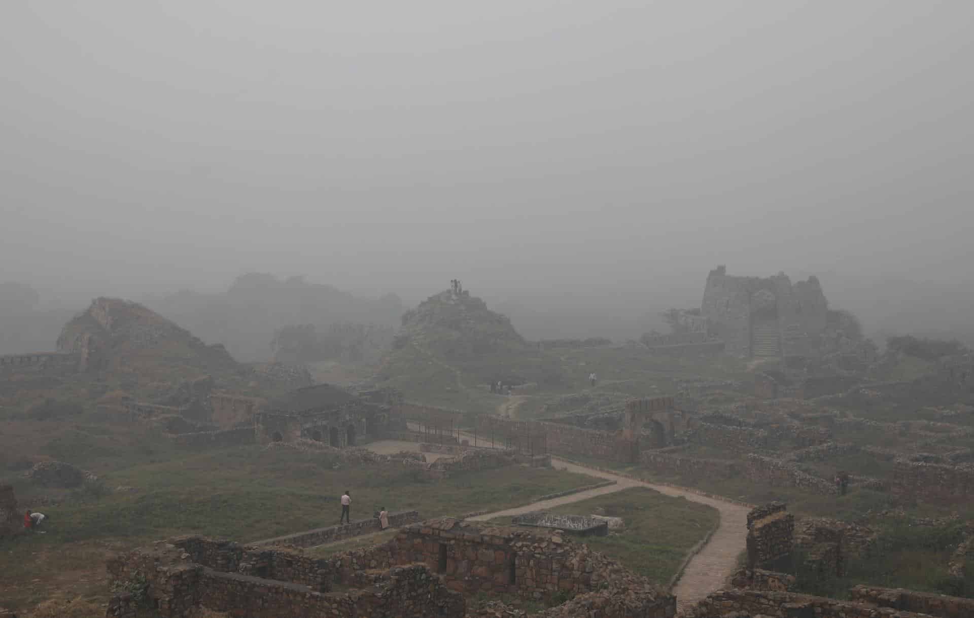 Visitantes en el fuerte de Tuglakabad en medio de una intensa niebla tóxica en Nueva Delhi, India. EFE/ Rajat Gupta