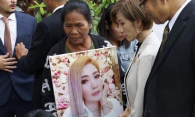 La madre de Siriporn Khanwong, asesinada por la tailandesa Sararat Rangsiwuthaporn -conocida como Am Cianuro-, sostiene un cartel con la foto de su hija tras conocer la condena a pena de muerte para la asesina.EFE/EPA/NARONG SANGNAK