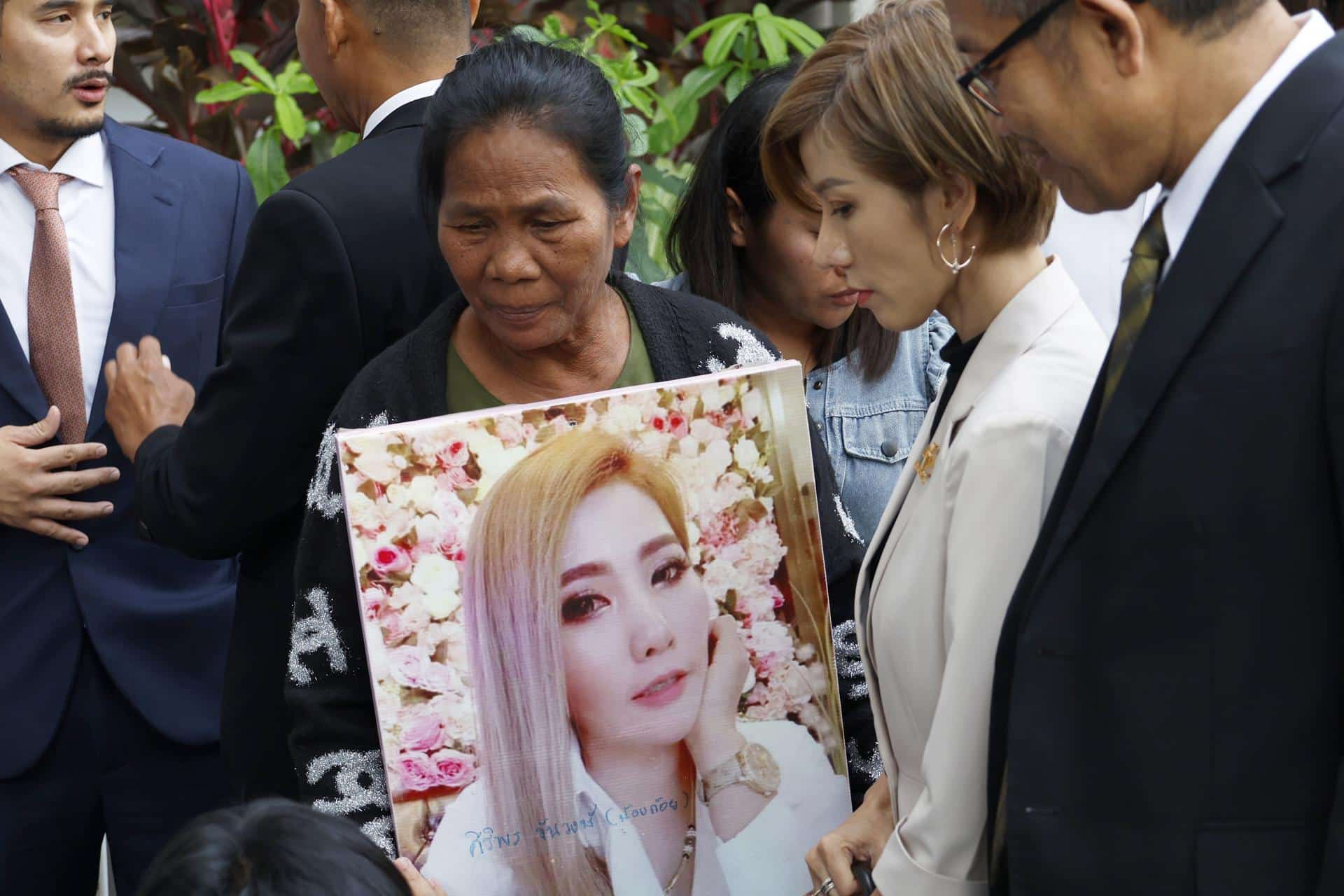 La madre de Siriporn Khanwong, asesinada por la tailandesa Sararat Rangsiwuthaporn -conocida como Am Cianuro-, sostiene un cartel con la foto de su hija tras conocer la condena a pena de muerte para la asesina.EFE/EPA/NARONG SANGNAK