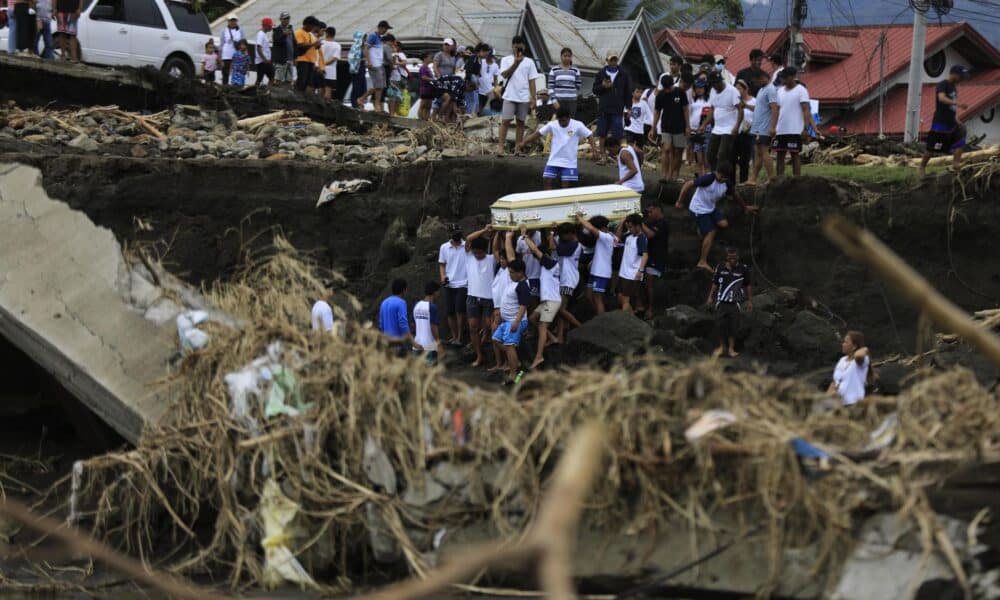 Unos vecinos llevan un ataúd el pasado miércoles en la provincia filipina de Batangas, en el norte del país, tras el paso de la tormenta tropical Trami, que causó 139 muertos y decenas de heridos. EFE/EPA/FRANCIS R. MALASIG