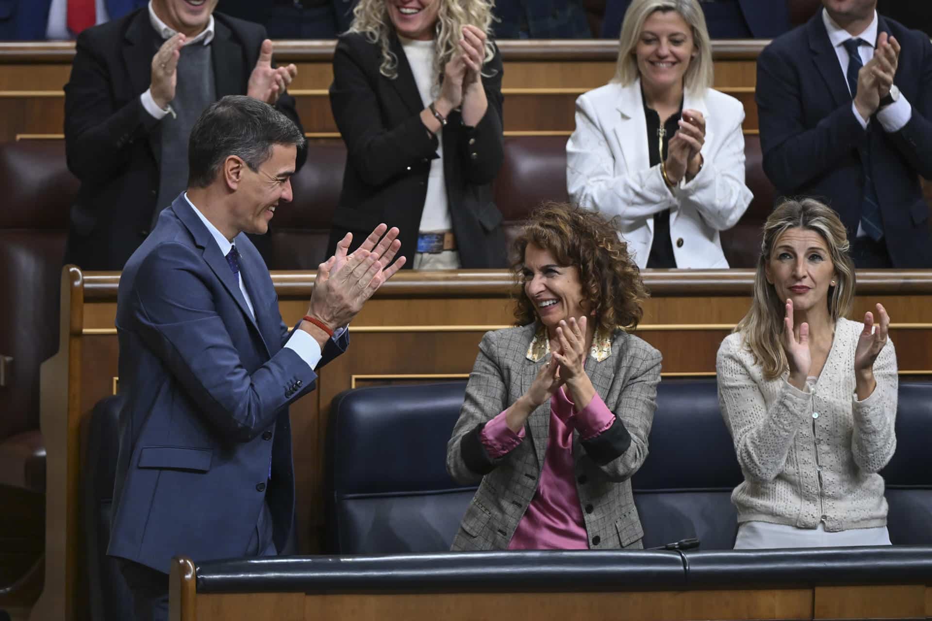 De izda a dcha; El presidente del Gobierno, Pedro Sánchez, y las vicepresidentas María Jesús Montero y Yolanda Díaz, aplauden durante el pleno celebrado este jueves en el Congreso de Los Diputados.- EFE/ Fernando Villar