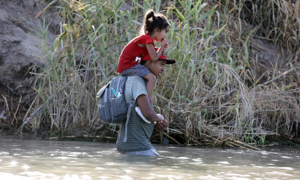 Fotografía de migrantes caminando por el río Grande en Eagle Pass, Texas, EE. UU. EFE/ADAM DAVIS