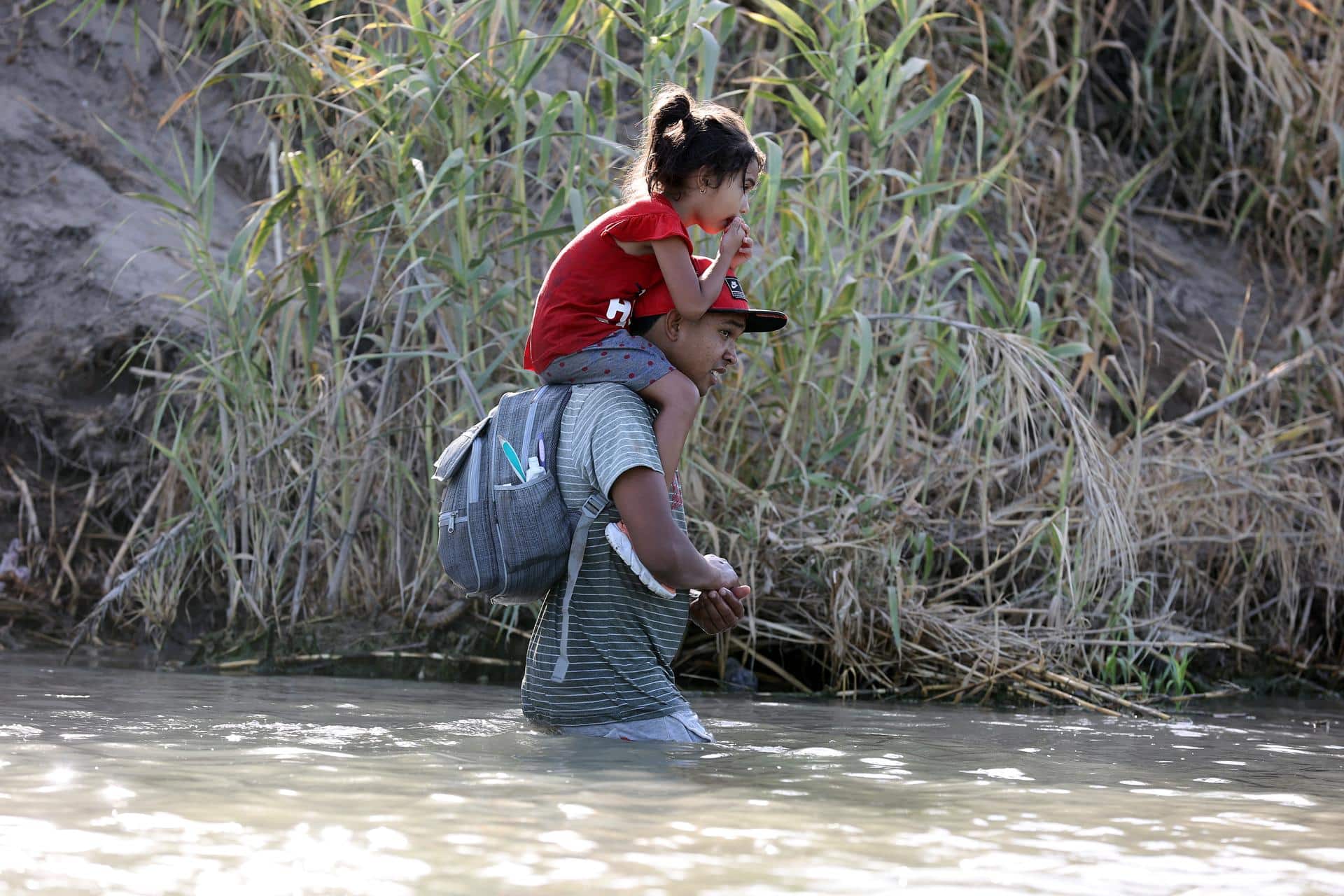 Fotografía de migrantes caminando por el río Grande en Eagle Pass, Texas, EE. UU. EFE/ADAM DAVIS