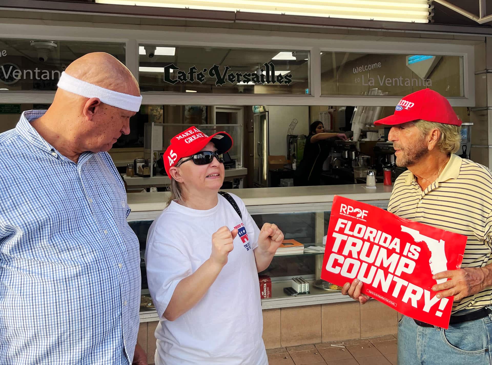 Ania Fresquet (c), una votante inscrita en la lista demócrata pero que vota por Donald Trump, habla con Osvaldo Hernández (i) y Miguel Saavedra (d), dos miembros de la 'Vigilia Mambisa', el lunes 4 de noviembre de 2024 en frente del icónico restaurante Versailles de la Pequeña Habana en Miami, Florida (EE.UU.). EFE/Ana Milena Varón