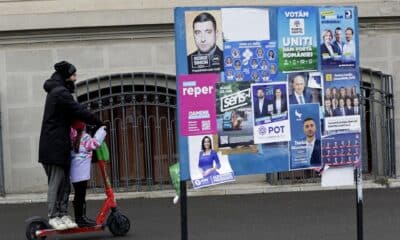 Un padre y una hija pasan por delante de unos carteles electorales en Bucarest. EFE/EPA/ROBERT GHEMENT