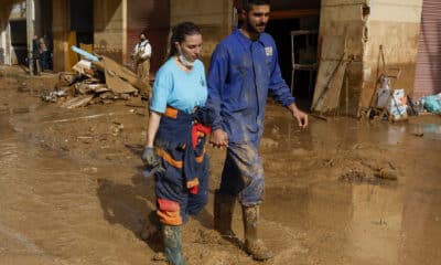 Una pareja camina este sábado por una calle en la localidad valenciana de Paiporta, que afronta el fin de semana con el reto de avanzar en la recuperación de la zona cero de la dana que asoló Valencia hace once días y de encontrar más personas desaparecidas. EFE/ Jorge Zapata