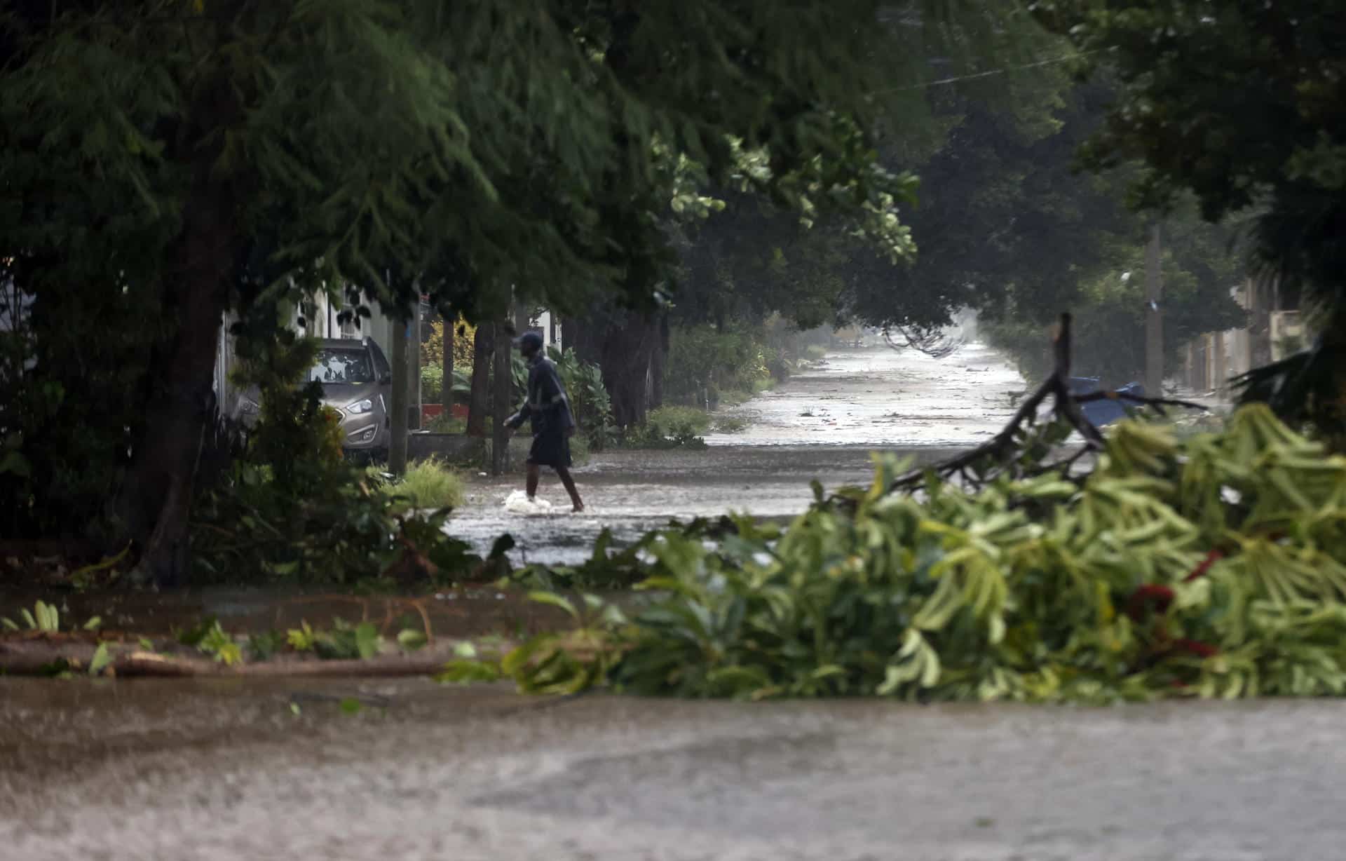 Una persona camina por una calle inundada de La Habana debido al paso del huracán Rafael. EFE/ Ernesto Mastrascusa