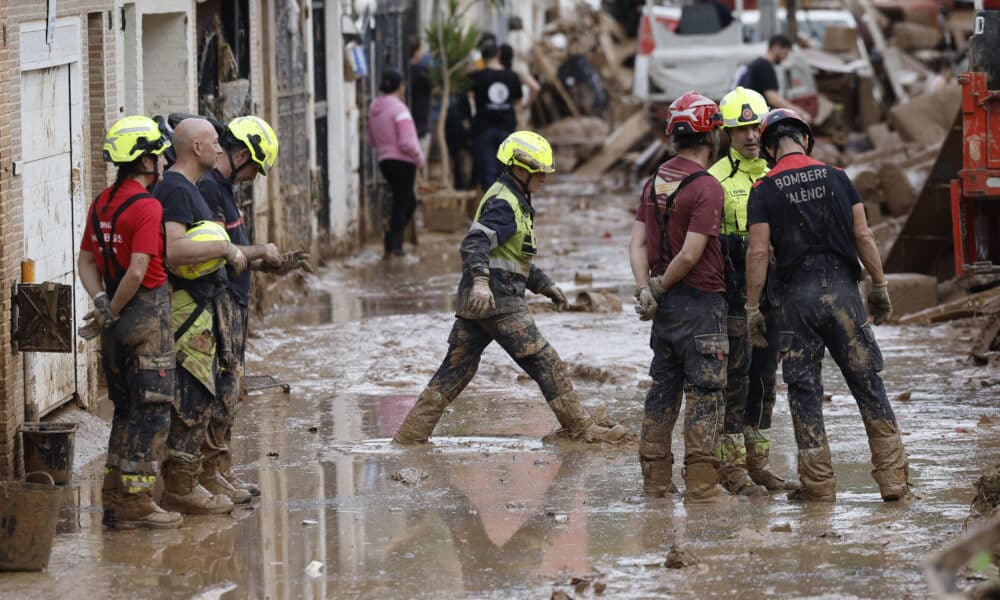 Efectivos del cuerpo de bomberos trabajan en la limpieza y retirada del lodo en Alfafar (Valencia), este viernes. EFE/ Kai Försterling