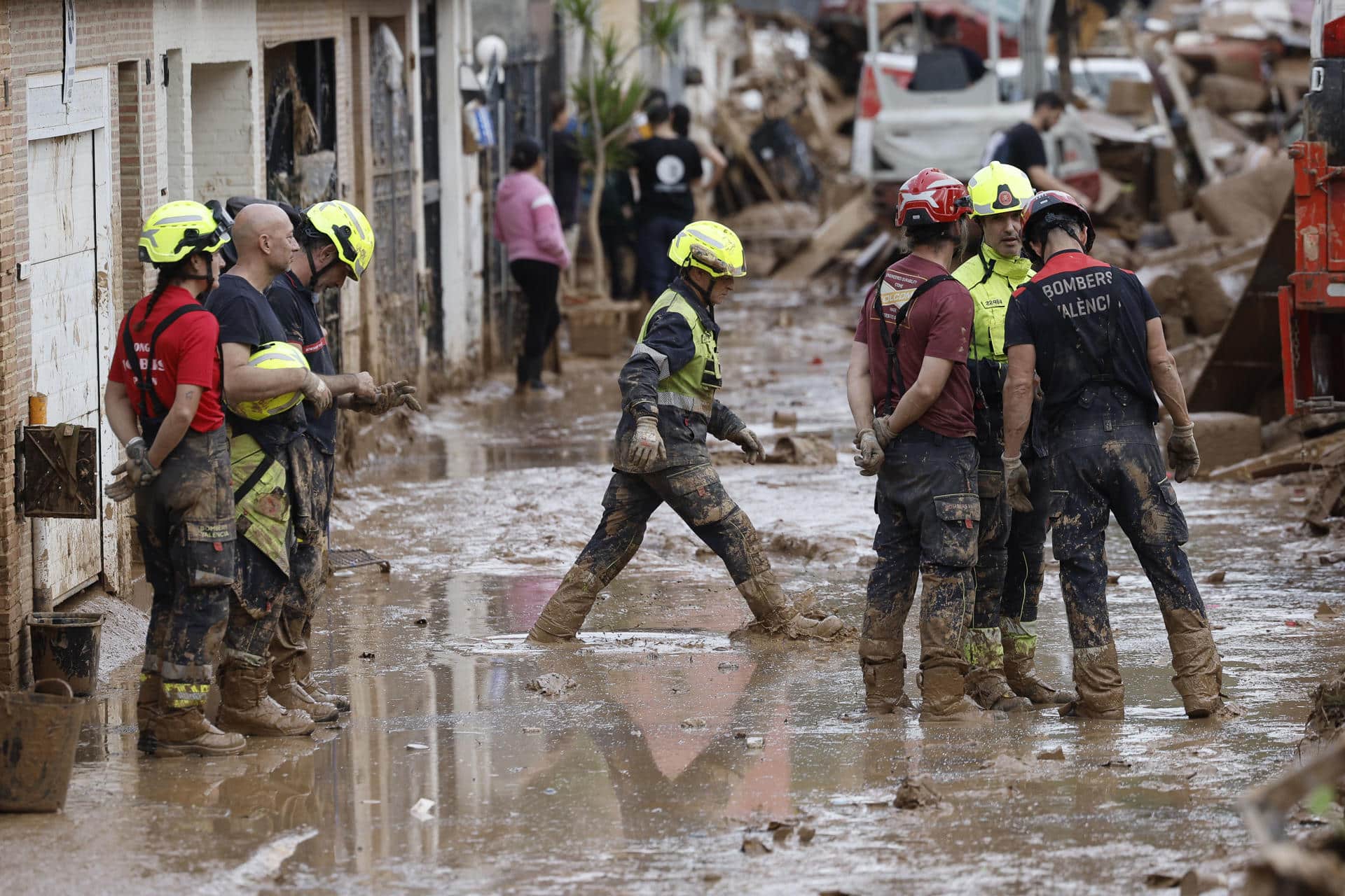 Efectivos del cuerpo de bomberos trabajan en la limpieza y retirada del lodo en Alfafar (Valencia), este viernes. EFE/ Kai Försterling