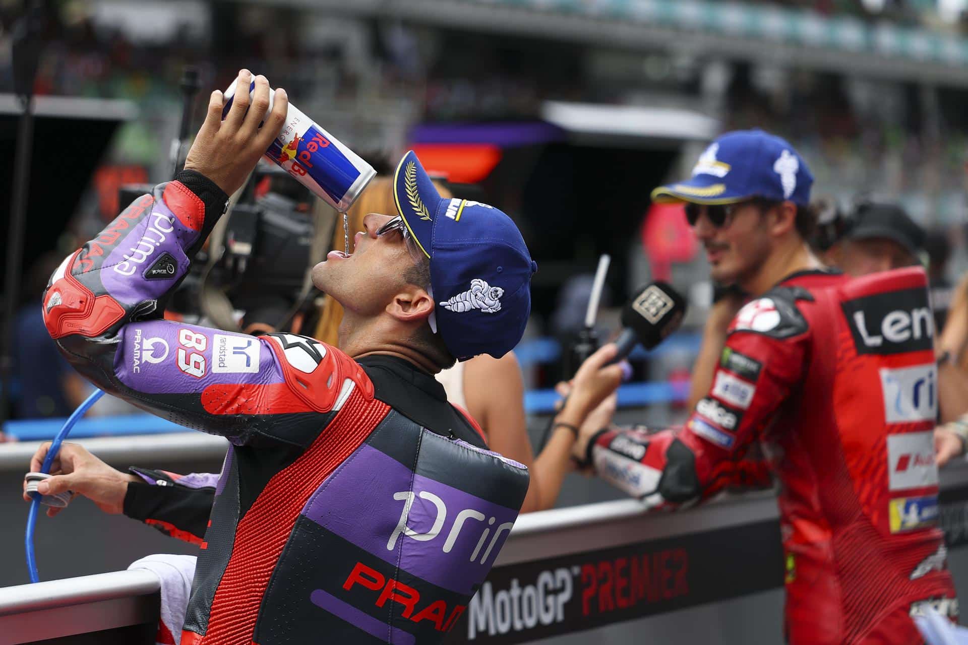 Jorge Martin (i) se refresca, mientras Francesco Bagnaia (d) es entrevistado durante el GP de Malasia. EFE/EPA/FAZRY ISMAIL