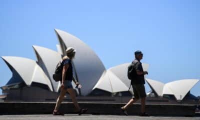 Dos personas pasan este martes delante de la Casa de la Ópera en Sídney en medio de una ola de claro. EFE/EPA/BIANCA DE MARCHI AUSTRALIA AND NEW ZEALAND OUT