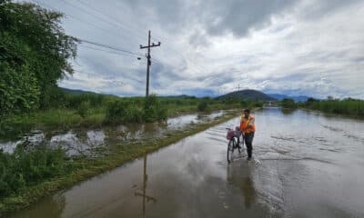 Una persona cruza con su bicicleta por una calle inundada. EFE/José Valle