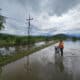 Una persona cruza con su bicicleta por una calle inundada. EFE/José Valle