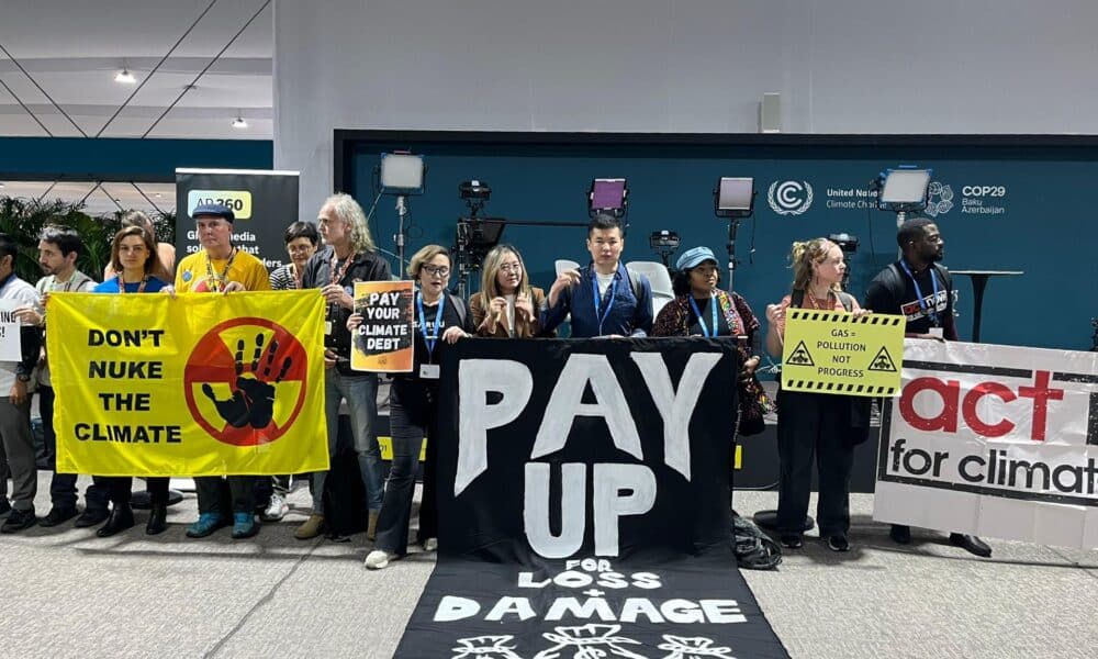 Cerca de un centenar de activistas se manifestaron hoy de manera casi silenciosa en la COP29 de Bakú, donde formaron una cadena en torno a salas de plenarios con pancartas y tararearon canciones de protesta, para denunciar que la organización de la cumbre les había prohibido hablar, cantar o dar palmas.EFE/Marta Montojo