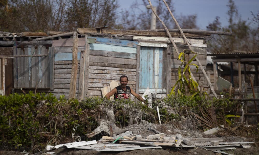 Un hombre espera entre los escombros junto a su casa afectada por el huracán Rafael, en Playa Guanimar, Artemisa (Cuba). EFE/Yander Zamora