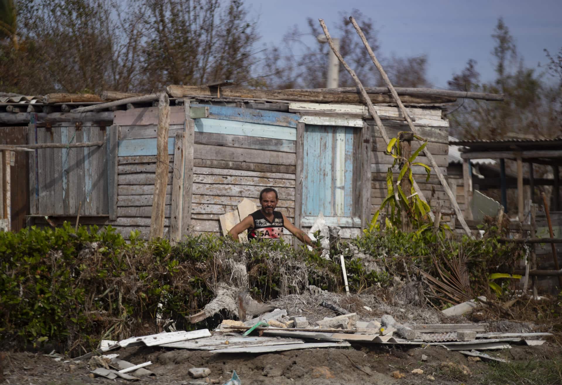 Un hombre espera entre los escombros junto a su casa afectada por el huracán Rafael, en Playa Guanimar, Artemisa (Cuba). EFE/Yander Zamora