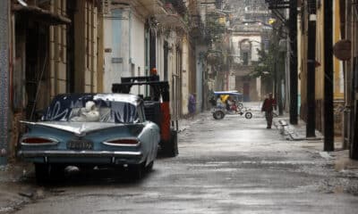 Personas caminan por una calle durante las fuertes lluvias debido al paso del huracán Rafael, ayer miércoles, en La Habana (Cuba). EFE/ Ernesto Mastrascusa