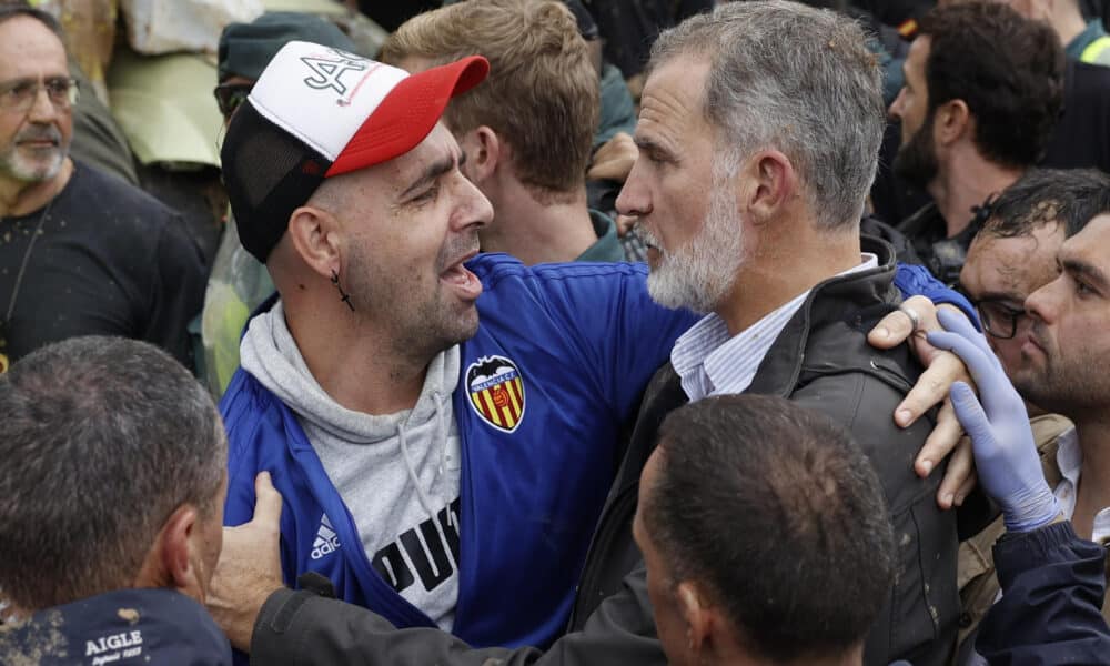 El rey Felipe consuela a un damnificado de las inundaciones durante su visita a la localidad valenciana de Paiporta este domingo, donde los reyes, el presidente del Gobierno, Pedro Sánchez, y el presidente regional de Valencia, Carlos Manzón, fueron recibidos con gritos de 'fuera', y el lanzamiento de barro por numerosas personas indignadas ante el retraso en la llegada de ayuda a ese pueblo, epicentro de la catástrofe. EFE/ Biel Aliño