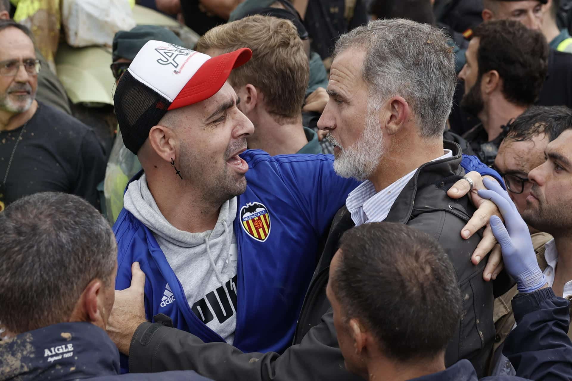 El rey Felipe consuela a un damnificado de las inundaciones durante su visita a la localidad valenciana de Paiporta este domingo, donde los reyes, el presidente del Gobierno, Pedro Sánchez, y el presidente regional de Valencia, Carlos Manzón, fueron recibidos con gritos de 'fuera', y el lanzamiento de barro por numerosas personas indignadas ante el retraso en la llegada de ayuda a ese pueblo, epicentro de la catástrofe. EFE/ Biel Aliño