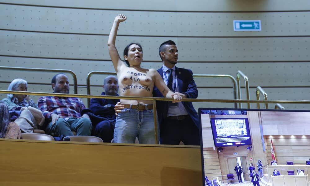 Una de las dos mujeres activistas de Femen con el torso desnudo y mensajes en favor del aborto escritos en su piel, que han interrumpido con gritos el pleno del Senado durante la sesión de control al Gobierno de este martes, antes de ser desalojadas de la tribuna de invitados. EFE/ Zipi