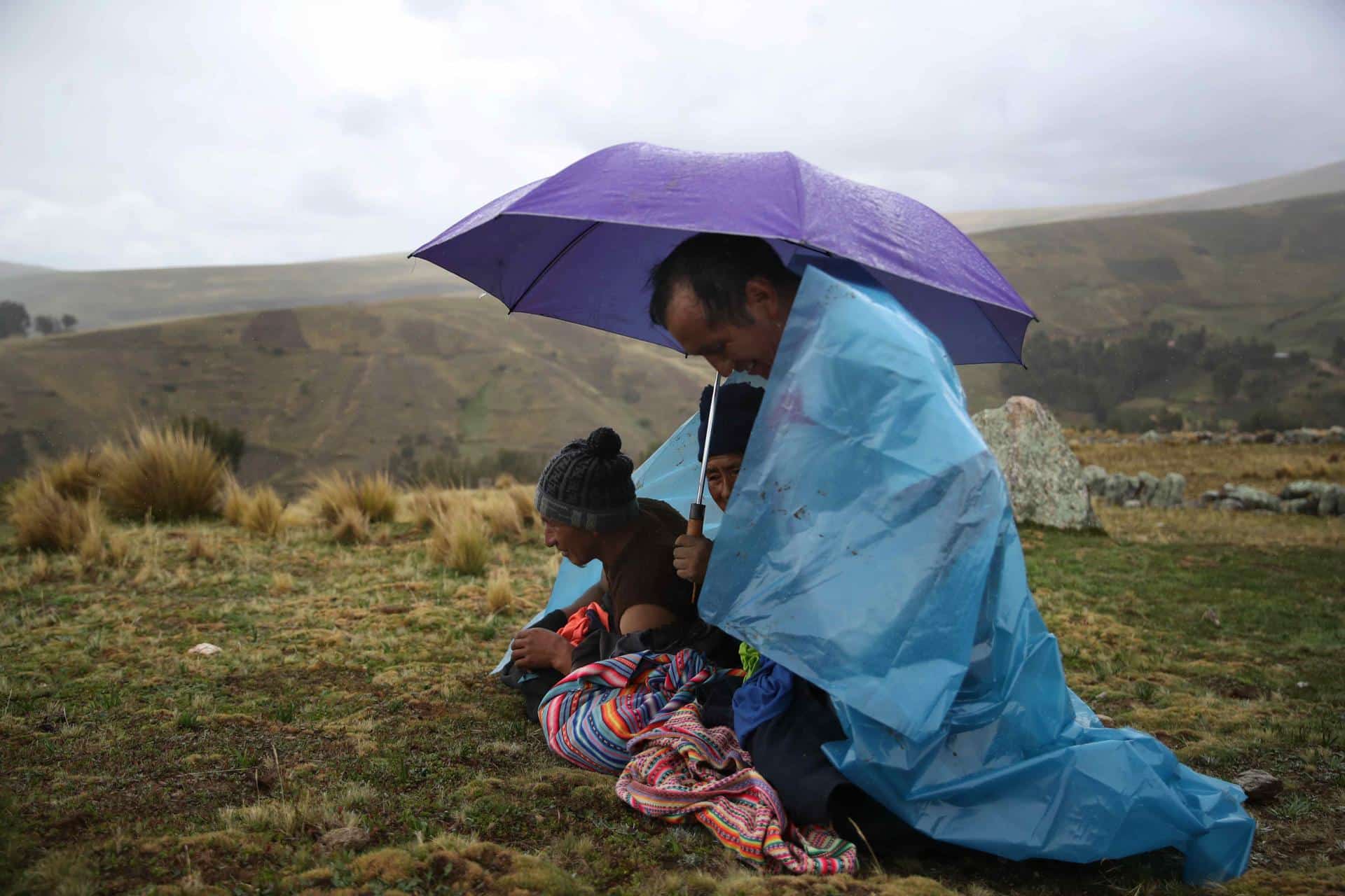 Fotografía de archivo en donde campesinos peruanos se resguardan de las lluvias. EFE/ Paolo Aguilar