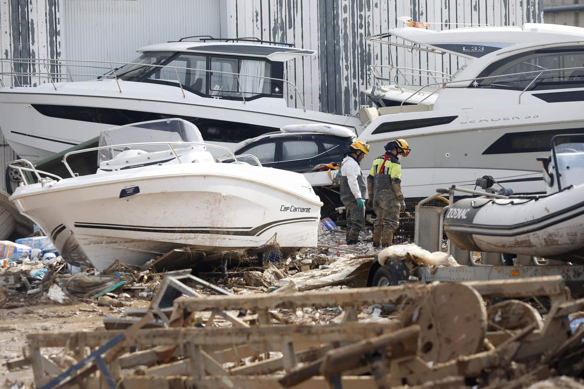 Dos bomberos inspeccionan las inmediaciones de una empresa con lanchas marinas en Massanassa, este miércoles. EFE/Miguel Ángel Polo