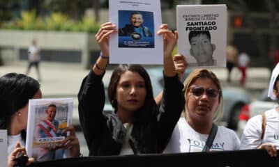 Familiares de detenidos sostienen retratos este jueves, afuera de la sede del Ministerio Público en Caracas (Venezuela). EFE/ Miguel Gutiérrez