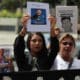 Familiares de detenidos sostienen retratos este jueves, afuera de la sede del Ministerio Público en Caracas (Venezuela). EFE/ Miguel Gutiérrez